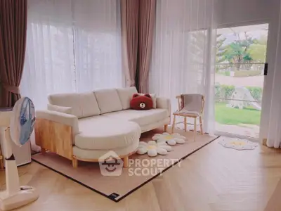 Charming living room with cozy sofa, elegant curtains, and garden view, perfect for relaxation and comfort.