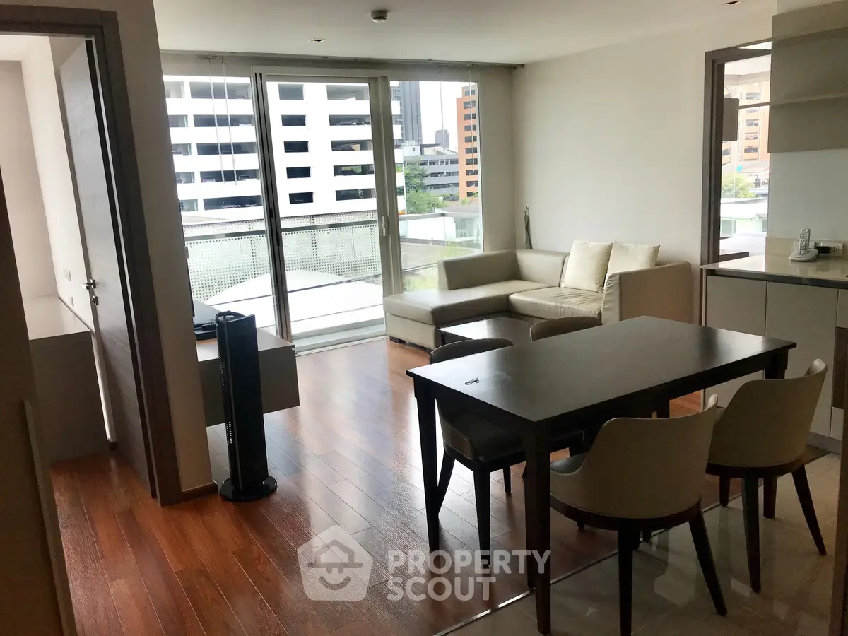 Modern living room with wooden floors and large windows in urban apartment