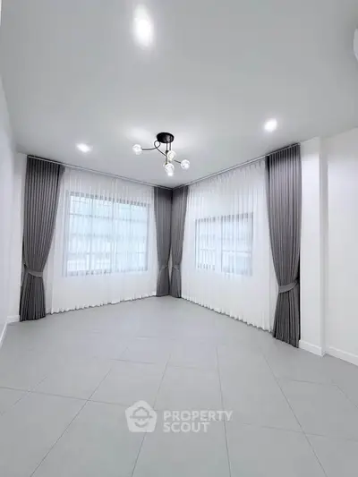 Spacious corner unit with elegant curtains and modern lighting in a bright living room.
