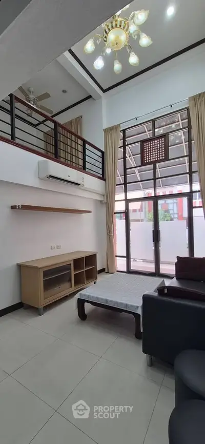 Spacious living room with high ceiling and modern decor in a stylish apartment.