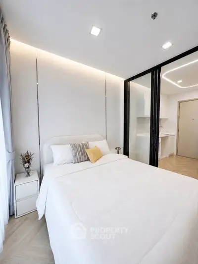 Modern bedroom with elegant decor and natural light, featuring a cozy bed and stylish furnishings.