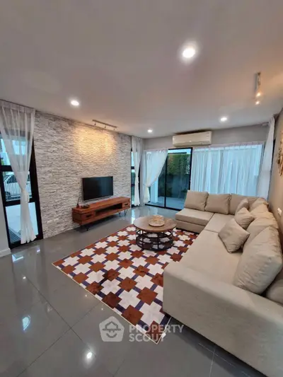 Spacious modern living room with stylish decor and large windows for natural light.