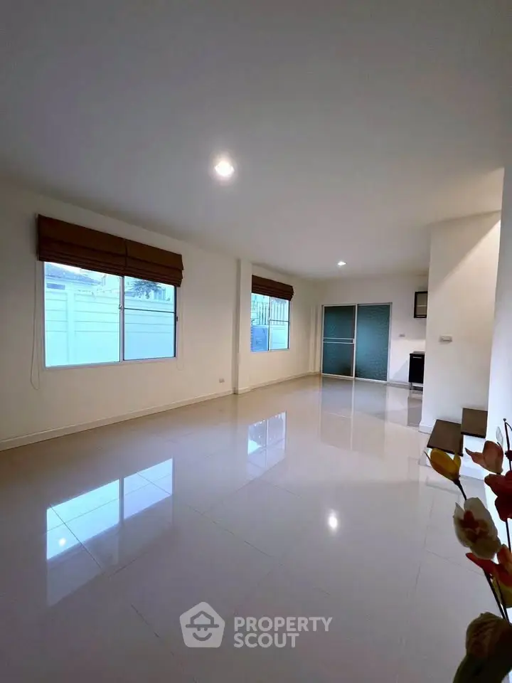 Spacious modern living room with large windows and glossy tile flooring