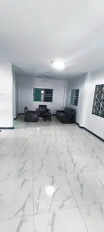 Spacious living room with modern marble flooring and cozy seating area.