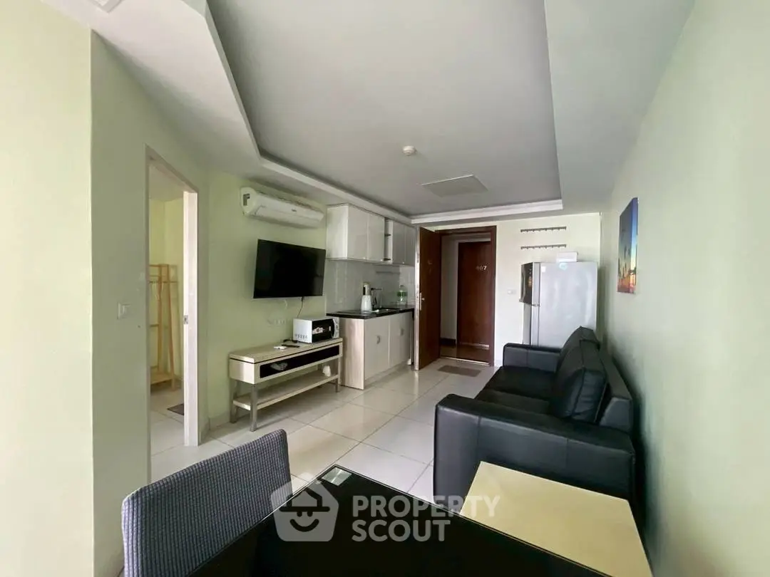 Modern living room with sleek furniture and open kitchen layout in a stylish apartment.