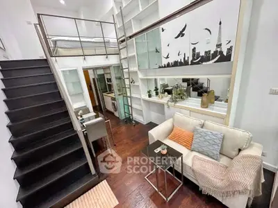 Stylish loft apartment with modern decor and mezzanine bedroom, featuring elegant staircase and cozy living area.