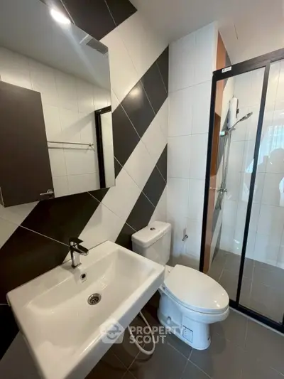 Modern bathroom with sleek fixtures and stylish diagonal tile design.