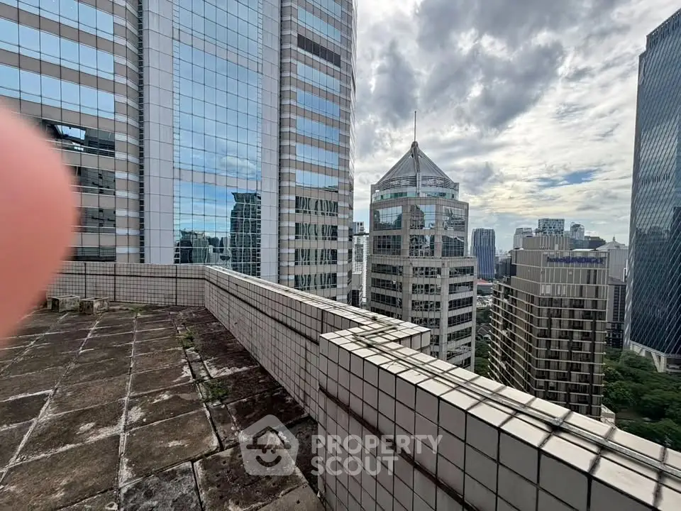 Stunning cityscape view from a high-rise building rooftop terrace, showcasing urban architecture and skyline.