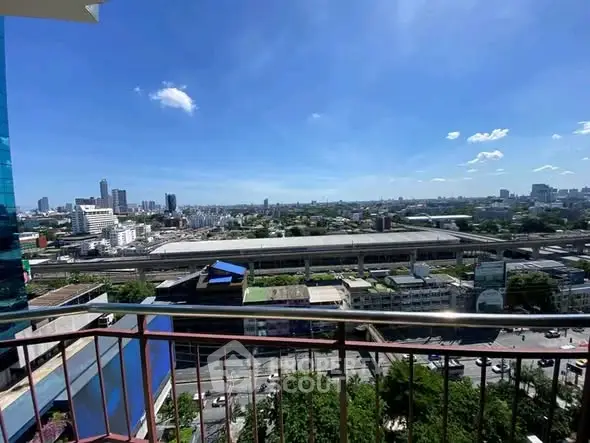 Stunning cityscape view from a high-rise balcony overlooking urban skyline and railway station.