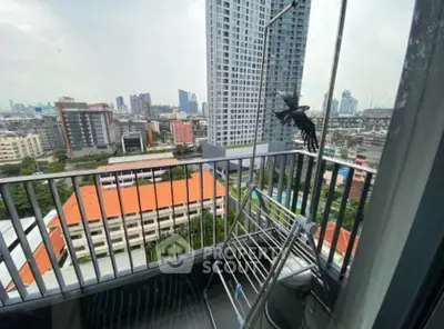 High-rise apartment balcony with cityscape view and drying rack.