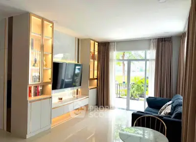 Modern living room with sleek entertainment center and large window overlooking greenery.