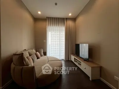 Cozy living room with modern sofa and flat-screen TV, perfect for relaxation.