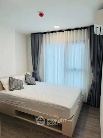 Modern bedroom with stylish curtains and cozy bed in a bright apartment.