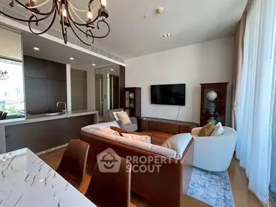Luxurious living room with modern decor, open kitchen layout, and elegant chandelier.