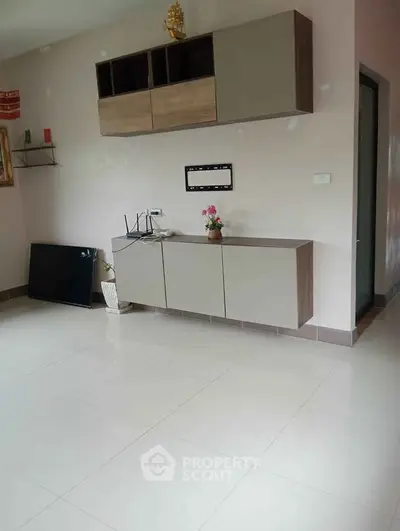 Spacious living room with modern cabinetry and sleek tile flooring, perfect for contemporary living.