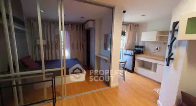 Modern studio apartment with sliding glass doors and compact kitchen