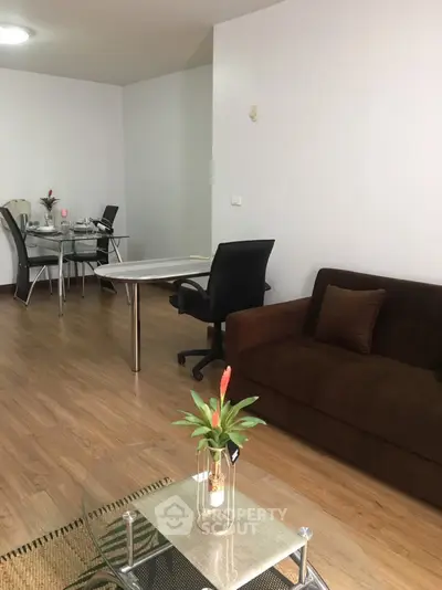 Modern living room with sleek furniture and wooden flooring, perfect for a cozy home office setup.