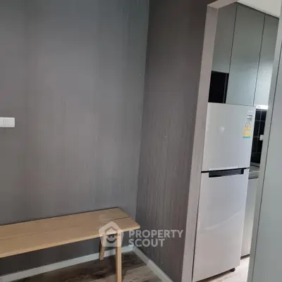 Modern kitchen corner with sleek fridge and minimalist wooden bench