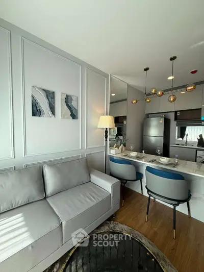 Modern living room with stylish kitchen, elegant decor, and cozy seating area in a contemporary apartment.