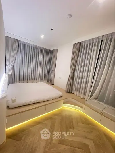 Modern bedroom with ambient lighting and large windows in a stylish apartment.