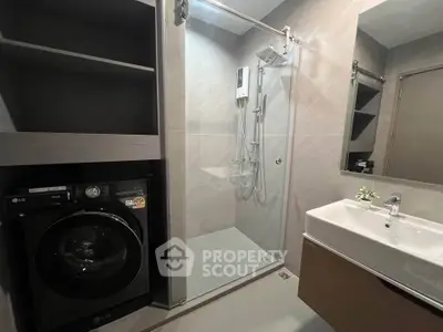 Modern bathroom with sleek shower and built-in washer, ideal for urban living.