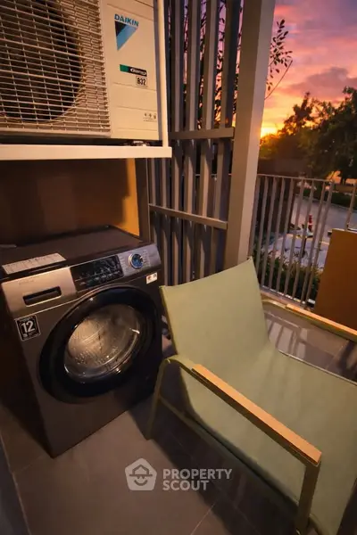 Charming balcony with washing machine and sunset view, perfect for relaxation and convenience.