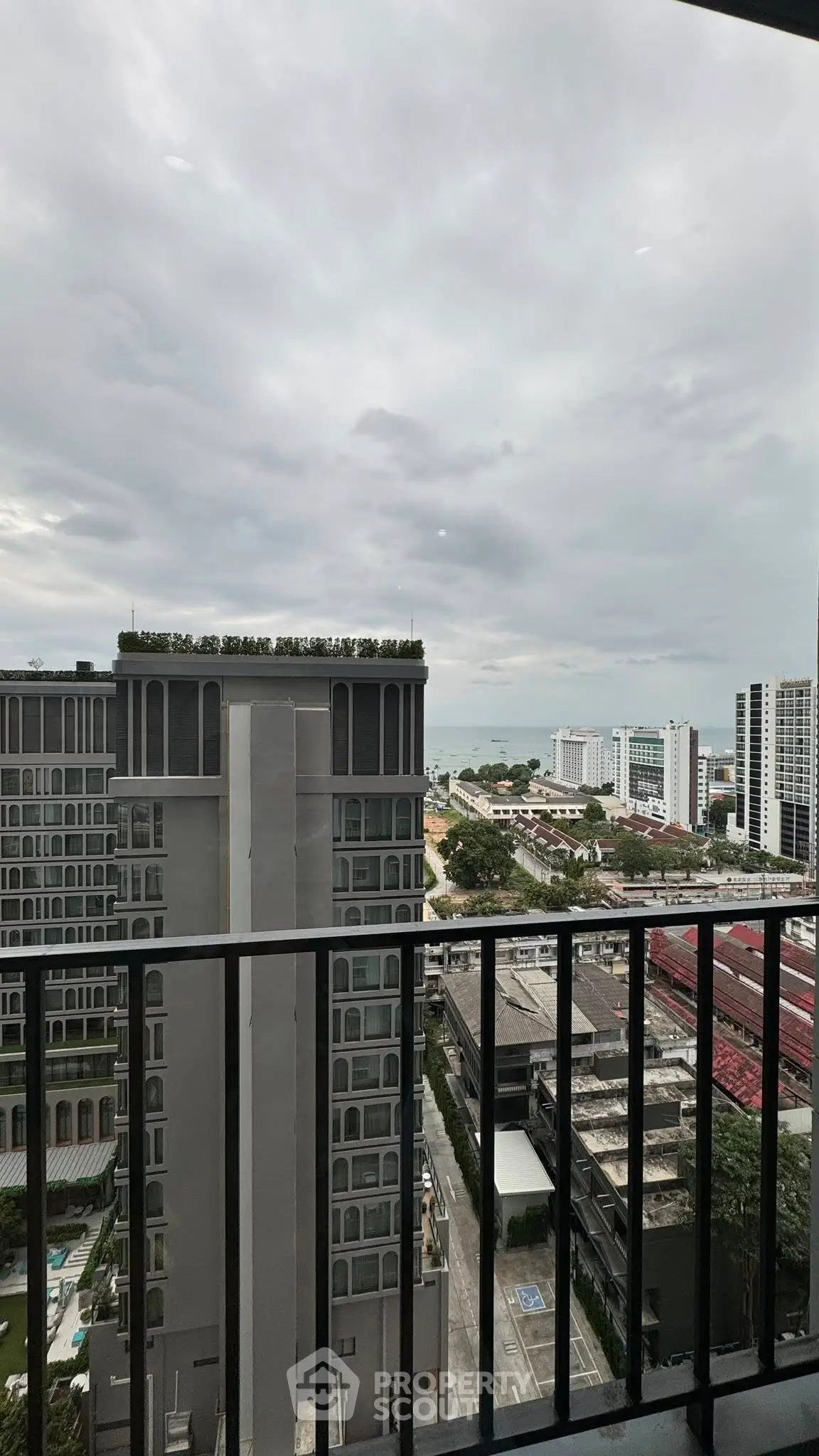 Stunning high-rise building view with ocean backdrop from balcony.
