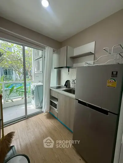 Modern compact kitchen with balcony view and sleek appliances