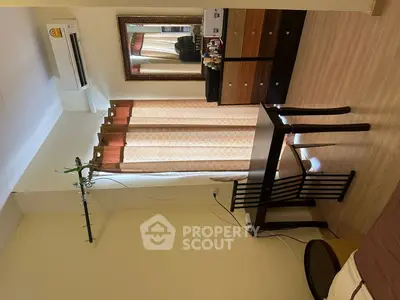 Cozy bedroom with wooden furniture and air conditioning, ideal for comfort and relaxation.