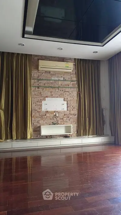 Spacious living room with wooden flooring and elegant curtains