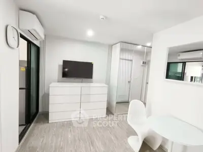 Modern minimalist living room with sleek white furniture and wall-mounted TV, featuring a stylish open layout.