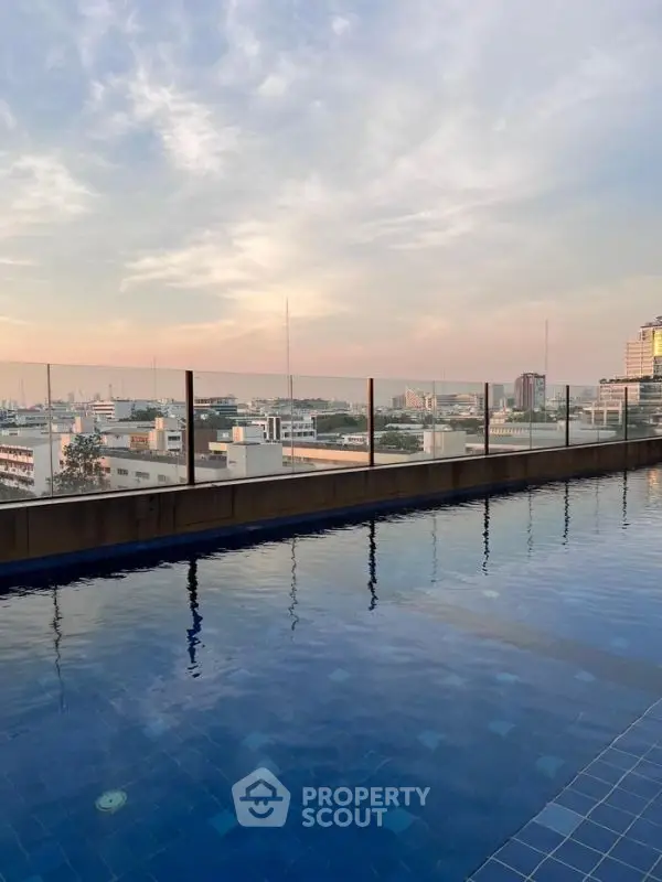 Stunning rooftop pool with panoramic city views at sunset.