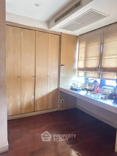 Spacious study room with wooden flooring and built-in storage
