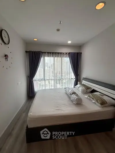 Modern bedroom with city view, featuring sleek design and ample natural light.