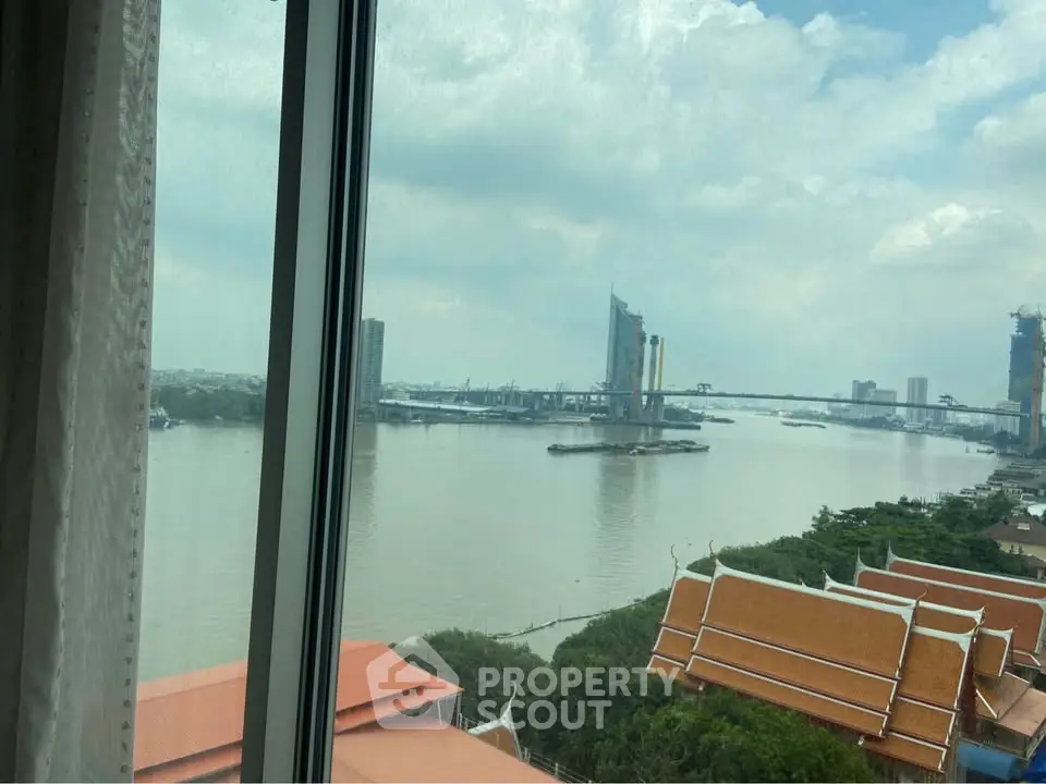 Stunning river view from high-rise window overlooking cityscape and bridge.