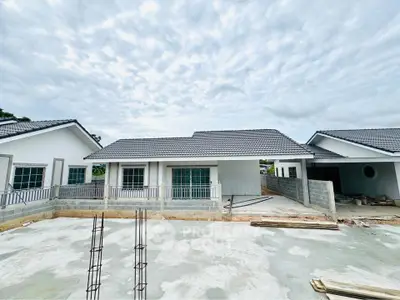 Modern single-story house under construction with tiled roof and spacious yard.
