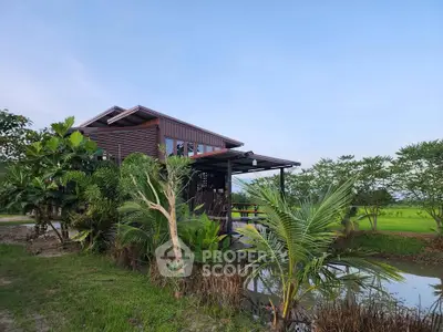 Charming wooden house with lush greenery and serene pond view, perfect for nature lovers seeking tranquility.