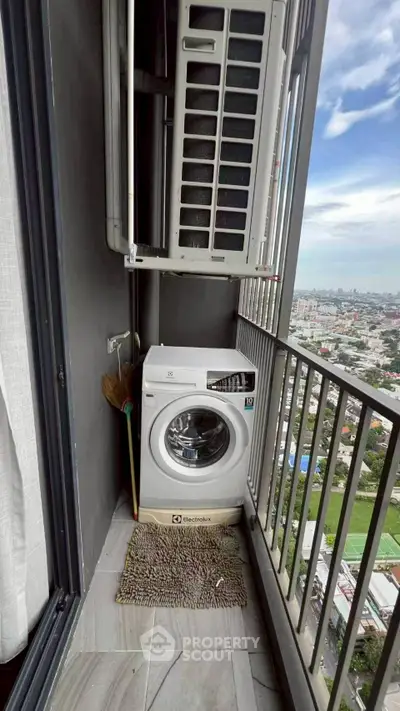 Compact balcony with washing machine and city view, perfect for urban living.