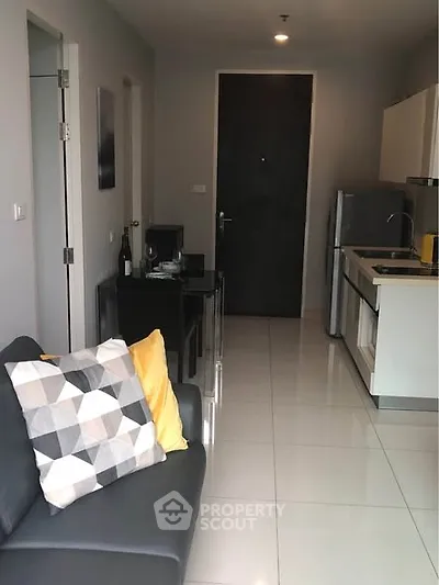 Modern apartment interior with sleek kitchen and cozy living area, featuring stylish decor and contemporary design.