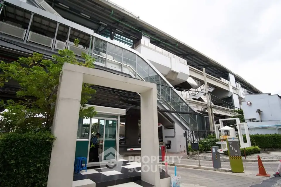 Modern building exterior with sleek design and lush greenery, showcasing urban architecture.