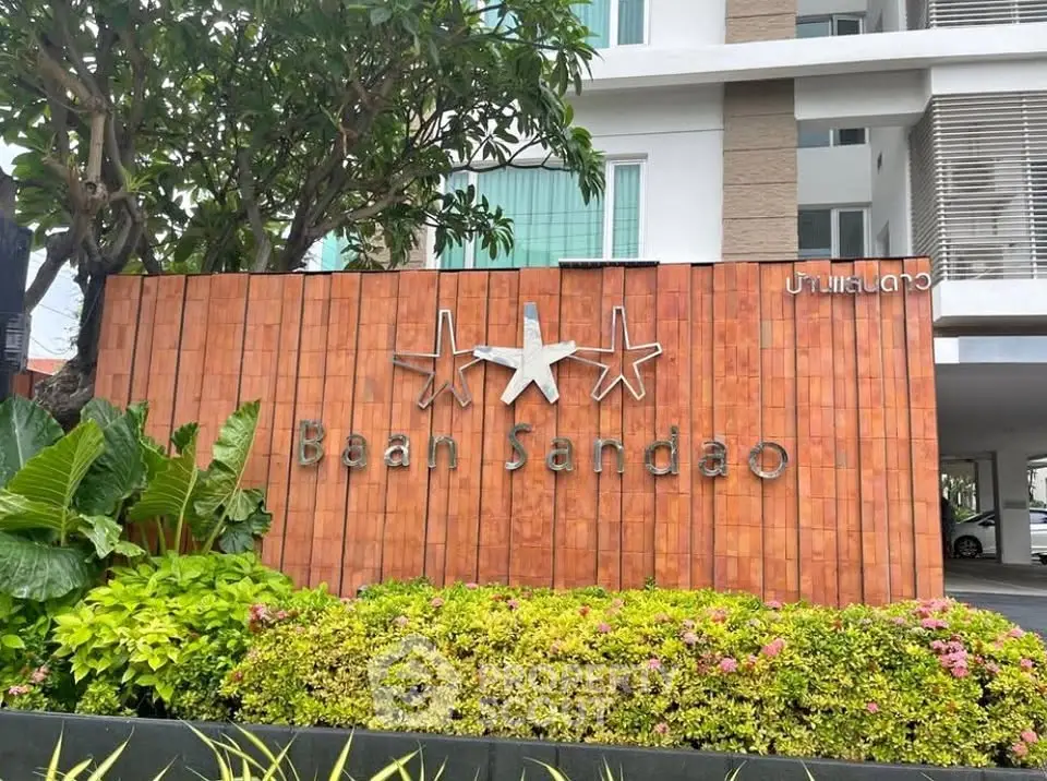 Modern building entrance with lush landscaping and stylish signage.