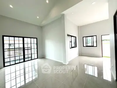 Spacious modern living room with large windows and glossy tile flooring