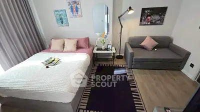 Modern bedroom with cozy bed and stylish sofa in a well-lit space.