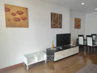 Modern living room with stylish decor and dining area, featuring elegant wall art and sleek furniture.