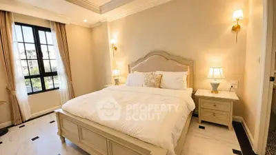 Luxurious bedroom with elegant decor and large windows offering natural light.