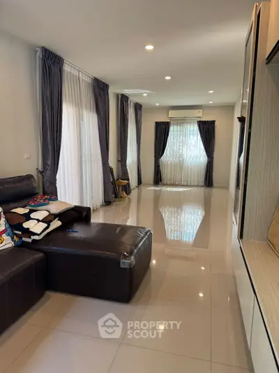 Spacious living room with elegant curtains and modern leather sofa