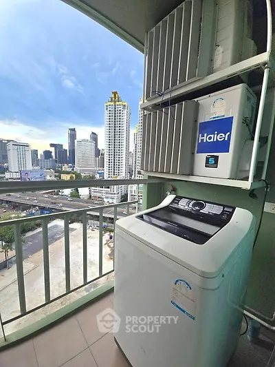 High-rise balcony with washing machine and city skyline view, perfect for urban living.