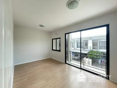 Spacious and well-lit corner unit with large windows offering an urban view, featuring sleek flooring and a versatile open layout.