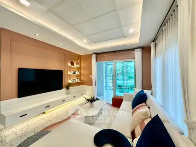 Luxurious living room with modern decor and large TV, featuring elegant lighting and garden view.