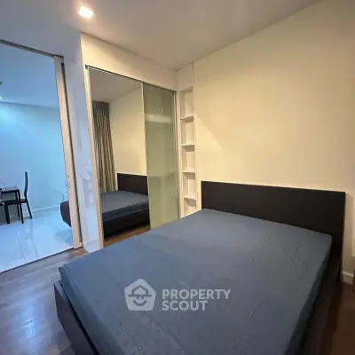 Modern bedroom with sleek design and mirrored closet doors in a stylish apartment.